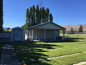 Building with covered porch and shed to the left