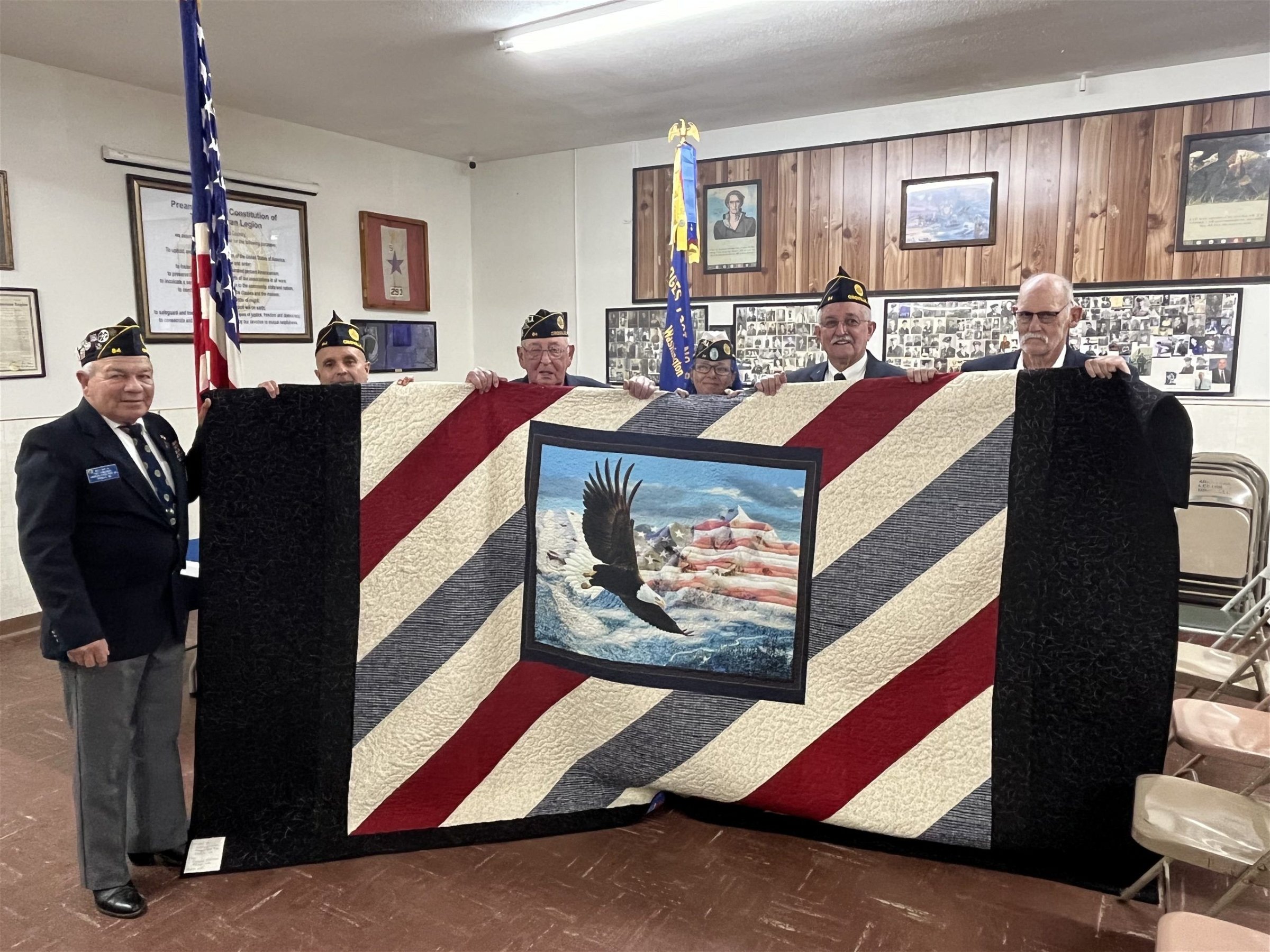 Newly-elected Post 84 officers stand with the donated quilt from the Highland Stitchers