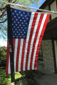 house-mounted US flag with black streamer for mourning