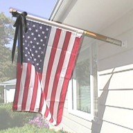 house mounted US flag with black bow for mourning