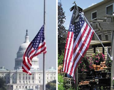 US flag on pole at half mast alongside residential mounted flag with black mourning streamer